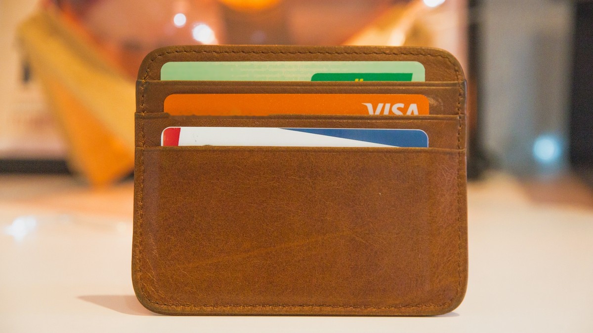 Leather wallet holding several payment cards, including a Visa card