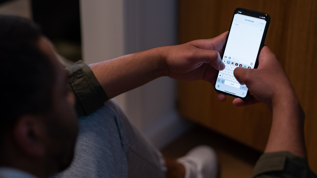 Man reading a text message on his smartphone at home